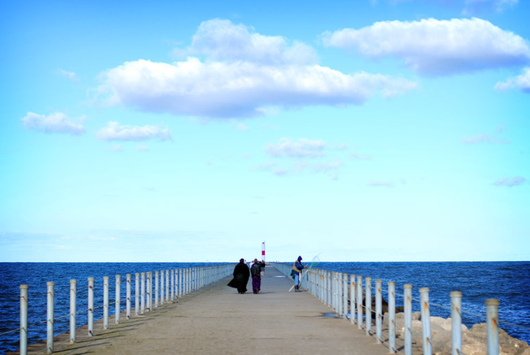 person with a trench coat on a blue sky day